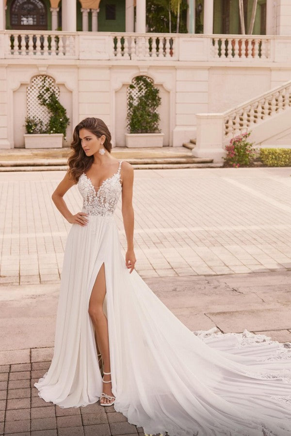 Robe de mariée longue ivoire élégante, coupe trapèze, bretelles spaghetti, décolleté en V en dentelle et fente.