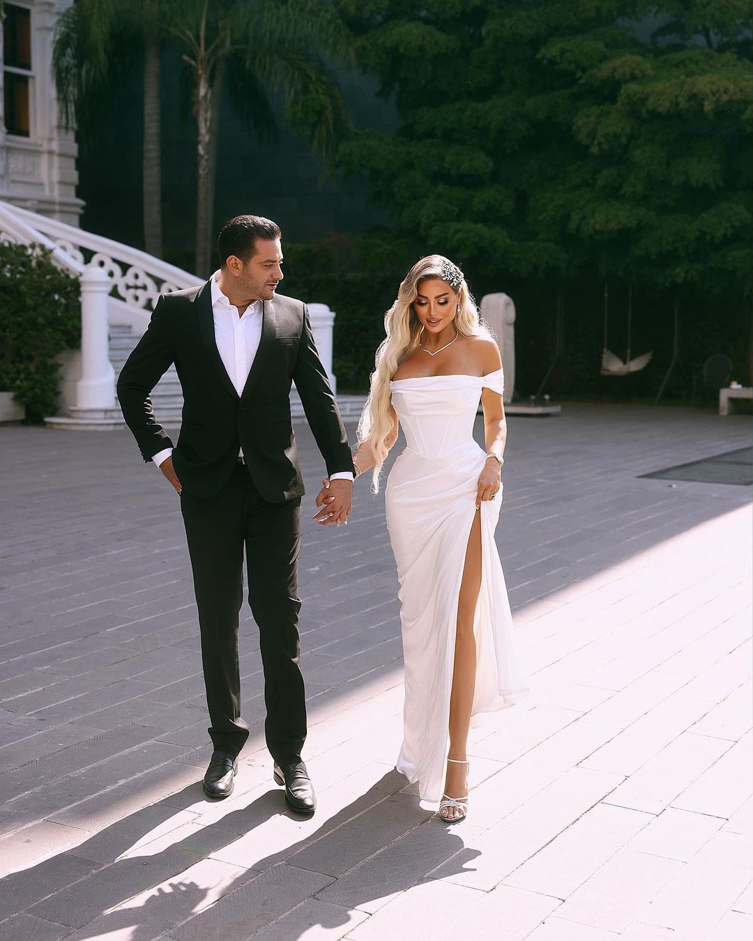 Robe de mariée longue et élégante en satin, épaules dénudées et fente.