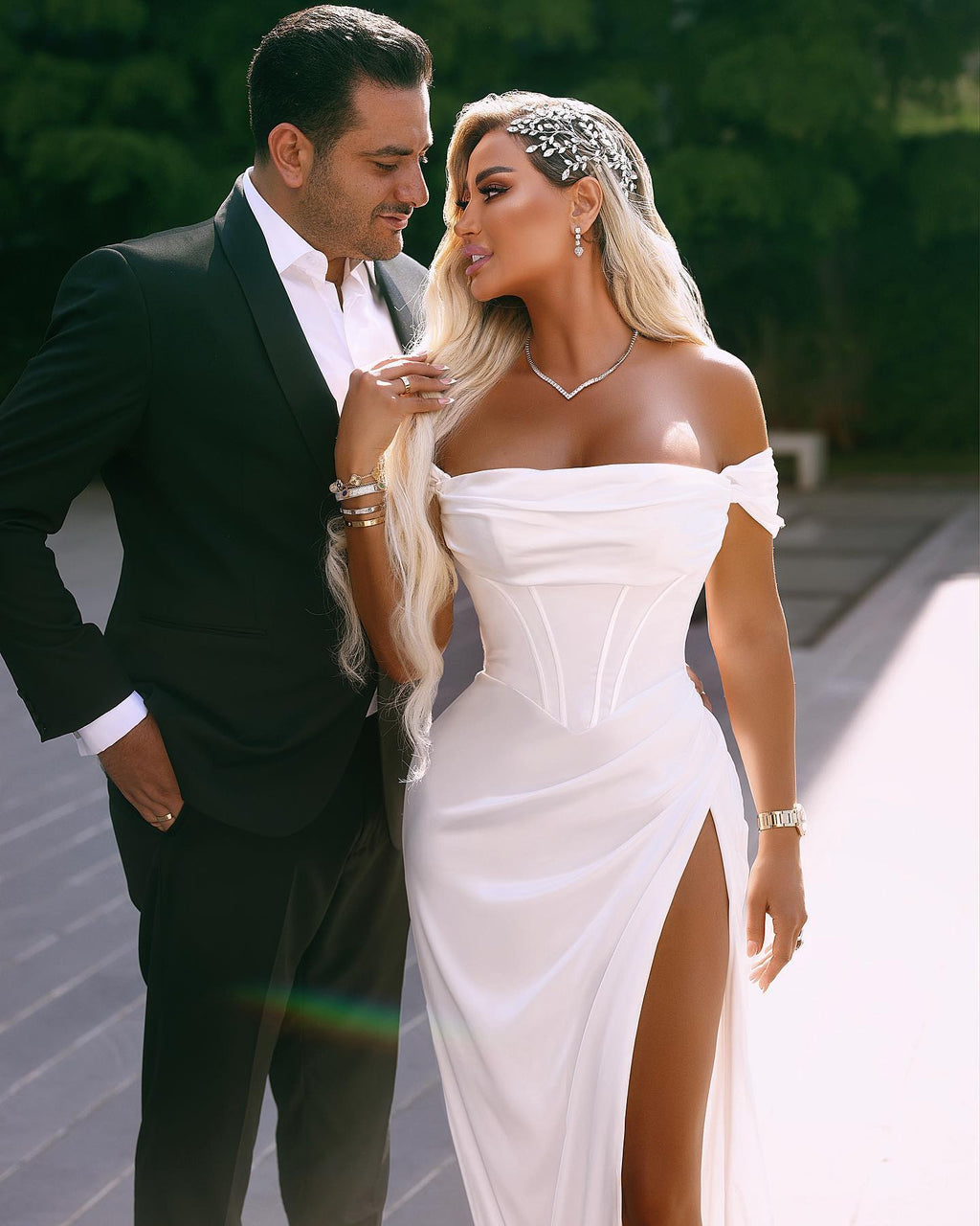 Robe de mariée longue et élégante en satin, épaules dénudées et fente.