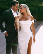Robe de mariée longue et élégante en satin, épaules dénudées et fente.