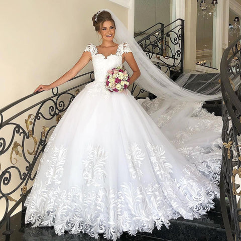 Elegante vestido de novia largo de princesa, de tul y encaje, con mangas cortas.