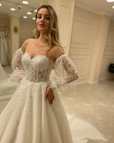 Elegante vestido de novia de manga larga, corte en A, escote corazón, espalda descubierta y apliques de encaje