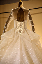 Elegante vestido de novia de tul con mangas largas, bordado con cuentas y cordones, con lentejuelas. 