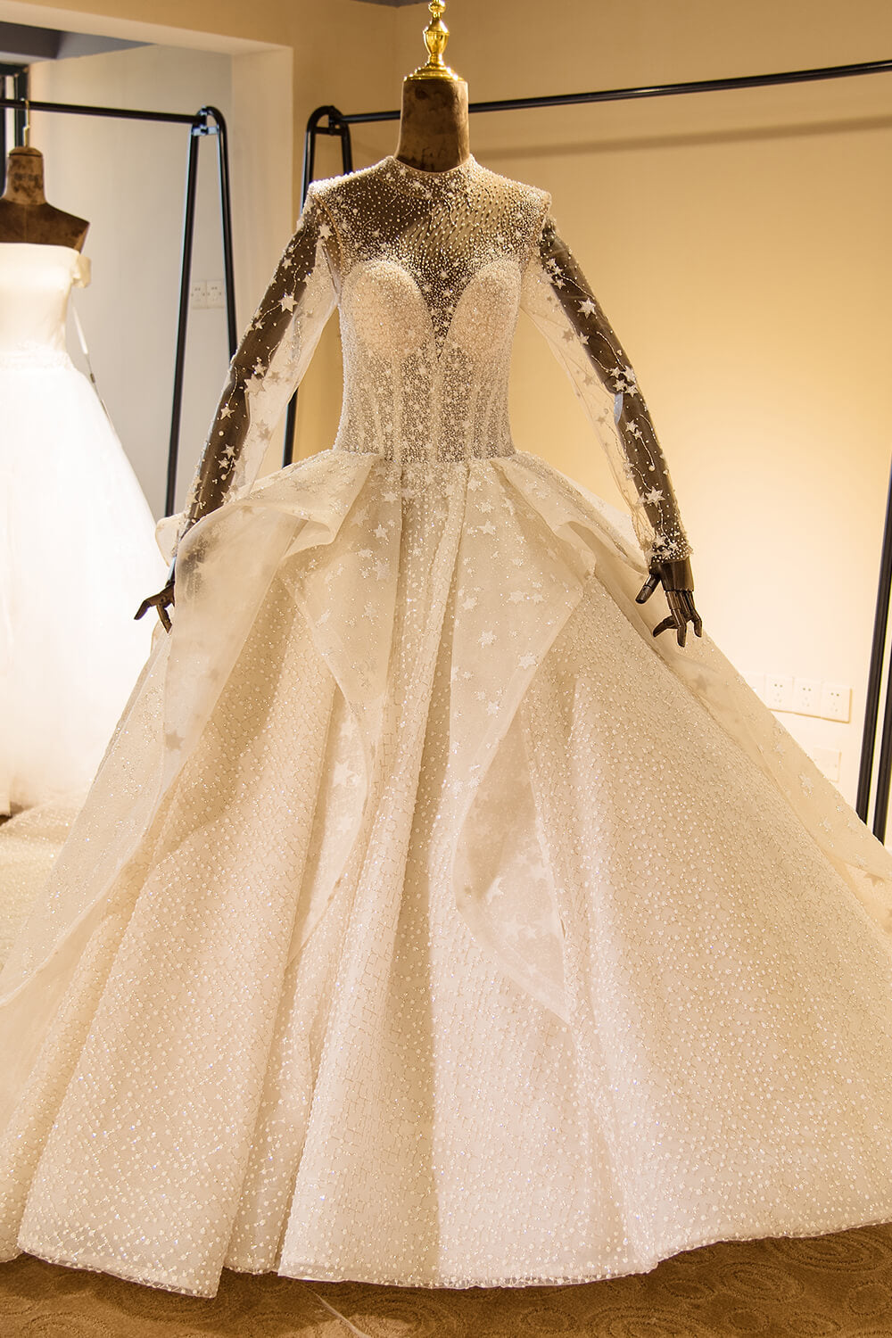 Elegante vestido de novia de tul con mangas largas, bordado con cuentas y cordones, con lentejuelas. 