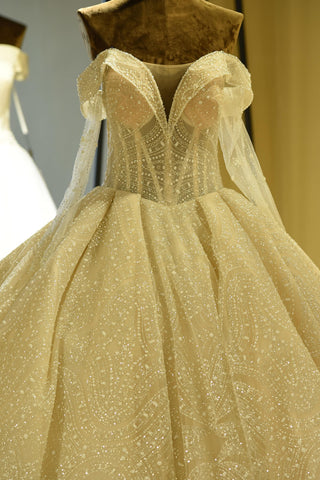 Elegante vestido de novia de corte princesa, de tul color marfil, con escote corazón y cordones, manga larga y escote corazón. 