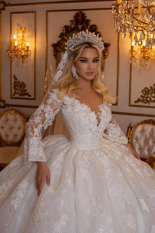 Elegante vestido de novia de corte princesa, manga larga, escote en V y escote corazón, con apliques de encaje.