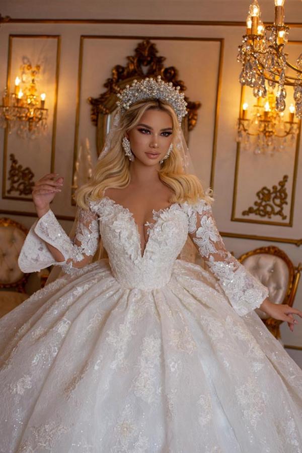 Robe de bal élégante à manches longues, décolleté en V et bustier cœur, ornée d'appliqués de dentelle.