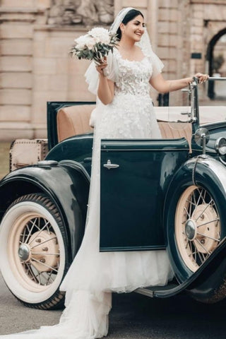 Elegante vestido de novia largo blanco de corte A, escote cuadrado, tul y encaje, con mangas cortas.