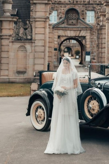 Élégante robe de mariée blanche longue en tulle et dentelle, coupe trapèze, col carré et manches courtes