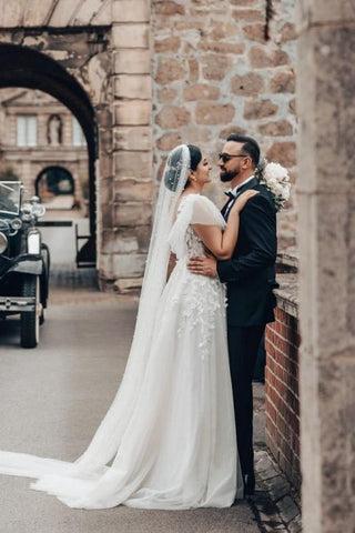 Elegante vestido de novia largo blanco de corte A, escote cuadrado, tul y encaje, con mangas cortas.