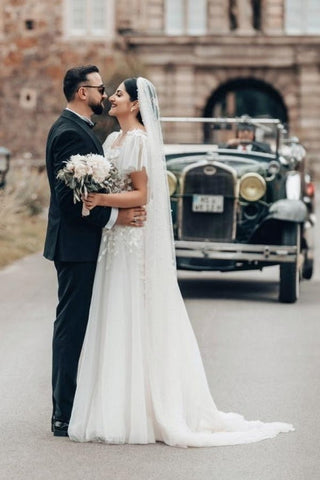 Elegante vestido de novia largo blanco de corte A, escote cuadrado, tul y encaje, con mangas cortas.