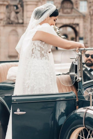 Elegante vestido de novia largo blanco de corte A, escote cuadrado, tul y encaje, con mangas cortas.