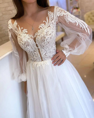 Elegante vestido de novia largo blanco de corte A, escote en V, mangas largas de tul y encaje.