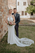 Elegante vestido de novia largo blanco de corte sirena, sin mangas, con espalda descubierta y cola, de encaje.