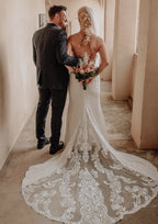 Elegante vestido de novia largo blanco de corte sirena, sin mangas, con espalda descubierta y cola, de encaje.