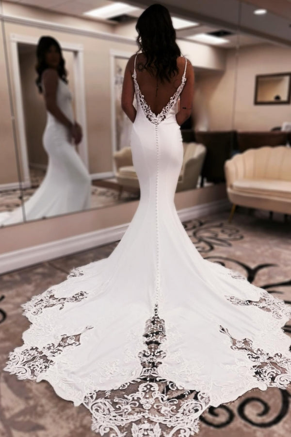 Elegante vestido de novia largo blanco de corte sirena, escote en V, tirantes finos, espalda descubierta y encaje.