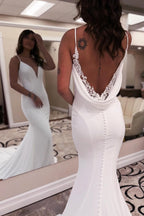 Elegante vestido de novia largo blanco de corte sirena, escote en V, tirantes finos, espalda descubierta y encaje.