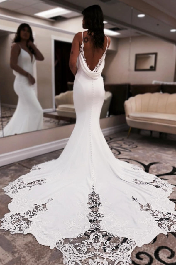Elegante vestido de novia largo blanco de corte sirena, escote en V, tirantes finos, espalda descubierta y encaje.