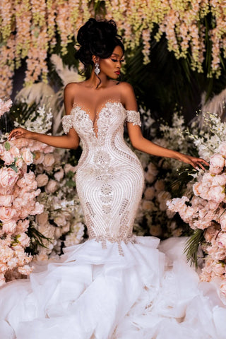 Elegantes vestidos de novia blancos sin mangas con encaje, escote barco y escote sirena, adornados con pedrería.