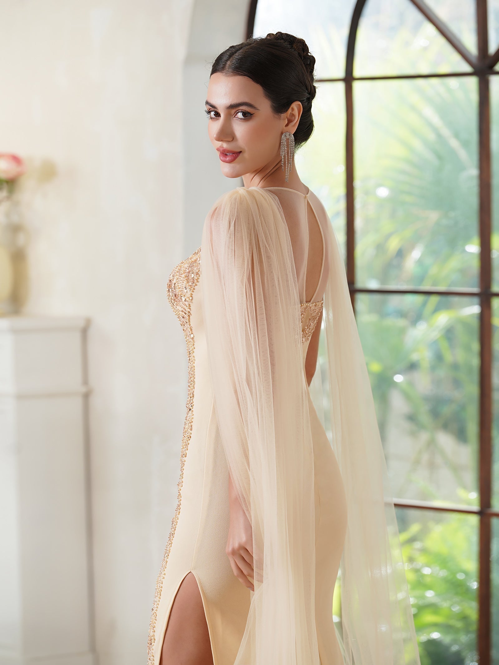 Elegante vestido de fiesta de sirena, sin mangas, de poliéster tejido de punto color oro champán, con escote redondo, detalles de pedrería y abertura con cremallera.