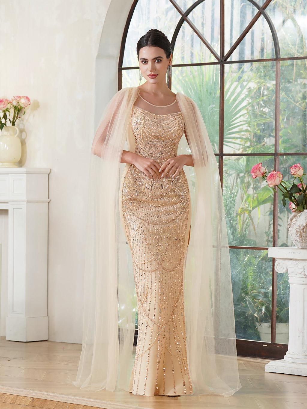 Elegante vestido de fiesta de sirena, sin mangas, de poliéster tejido de punto color oro champán, con escote redondo, detalles de pedrería y abertura con cremallera.