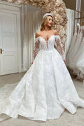 Elegante vestido de novia de encaje con escote corazón y mangas largas. Corte en A.