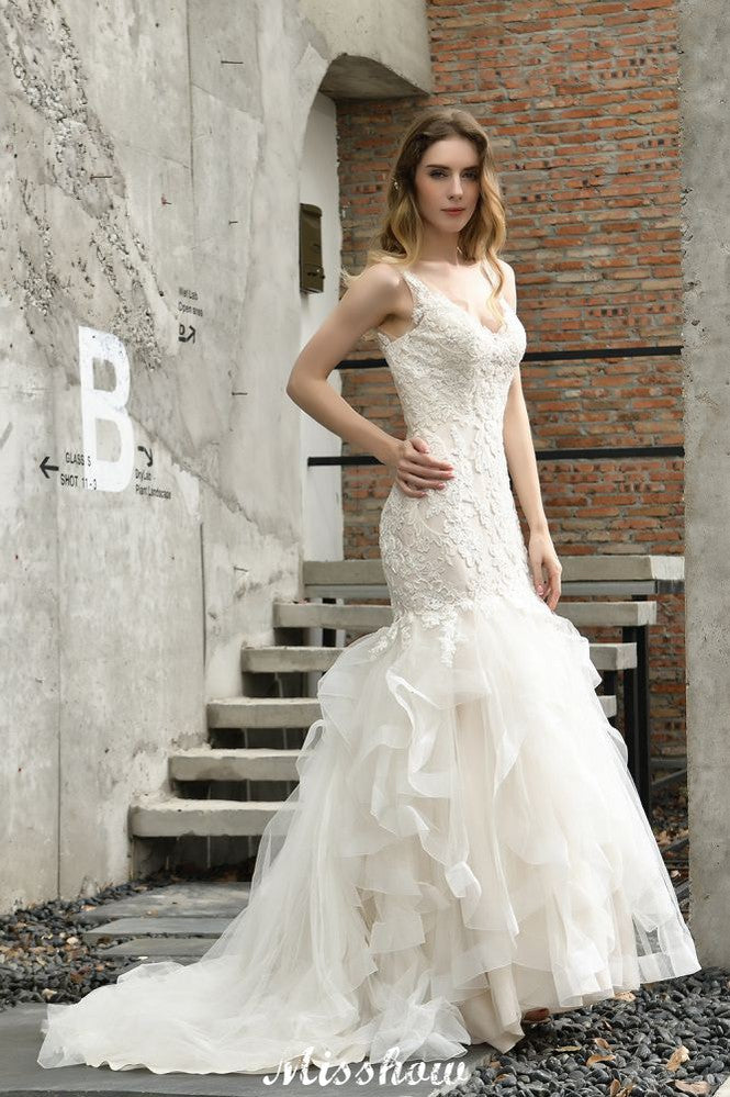 Robe de mariée sirène élégante à col en V, ornée de tulle et de dentelle, avec des appliques bouffantes.