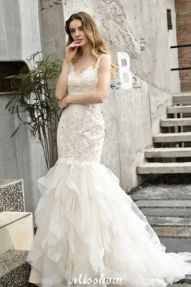 Robe de mariée sirène élégante à col en V, ornée de tulle et de dentelle, avec des appliques bouffantes.