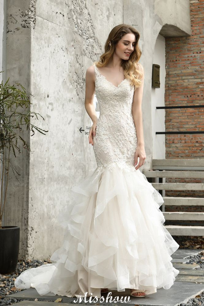 Robe de mariée sirène élégante à col en V, ornée de tulle et de dentelle, avec des appliques bouffantes.