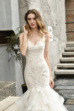 Robe de mariée sirène élégante à col en V, ornée de tulle et de dentelle, avec des appliques bouffantes.