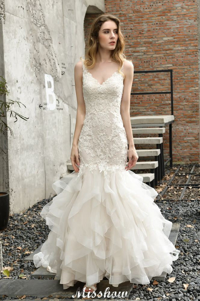 Robe de mariée sirène élégante à col en V, ornée de tulle et de dentelle, avec des appliques bouffantes.