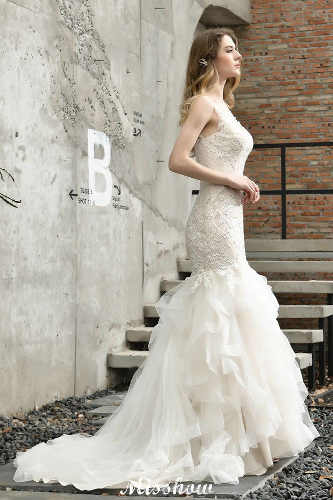 Robe de mariée sirène élégante à col en V, ornée de tulle et de dentelle, avec des appliques bouffantes.