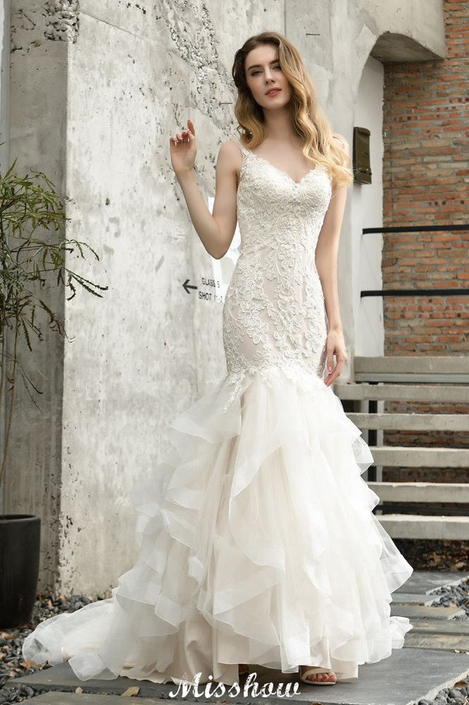 Robe de mariée sirène élégante à col en V, ornée de tulle et de dentelle, avec des appliques bouffantes.
