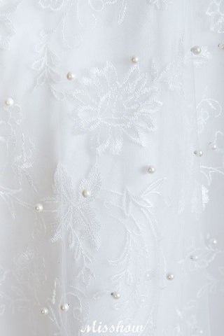 Elegante vestido de novia de playa con escote en V, tul y perlas.