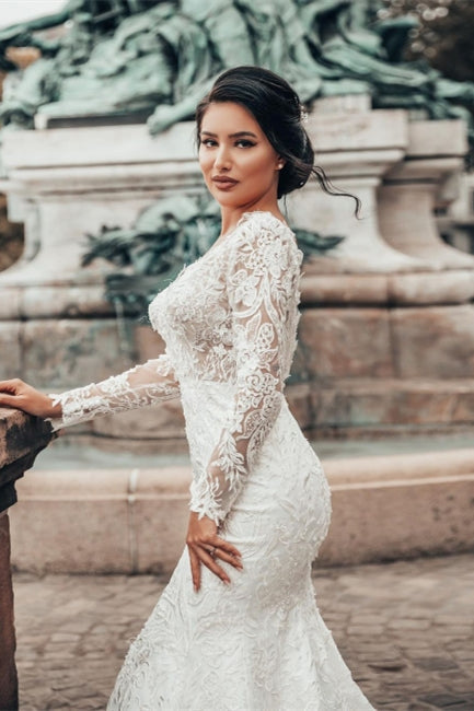 Robe de mariée sirène élégante en dentelle florale blanche, manches longues, col en V, coupe cintrée. 