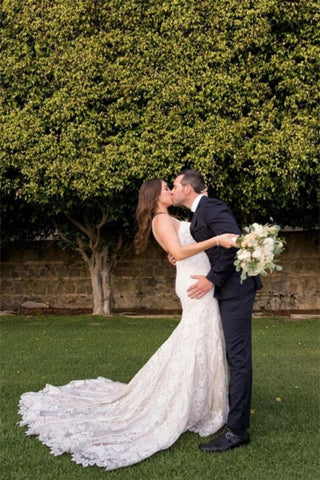 Elegantes vestidos de novia blancos de corte sirena, con escote en V, espalda descubierta y encaje.