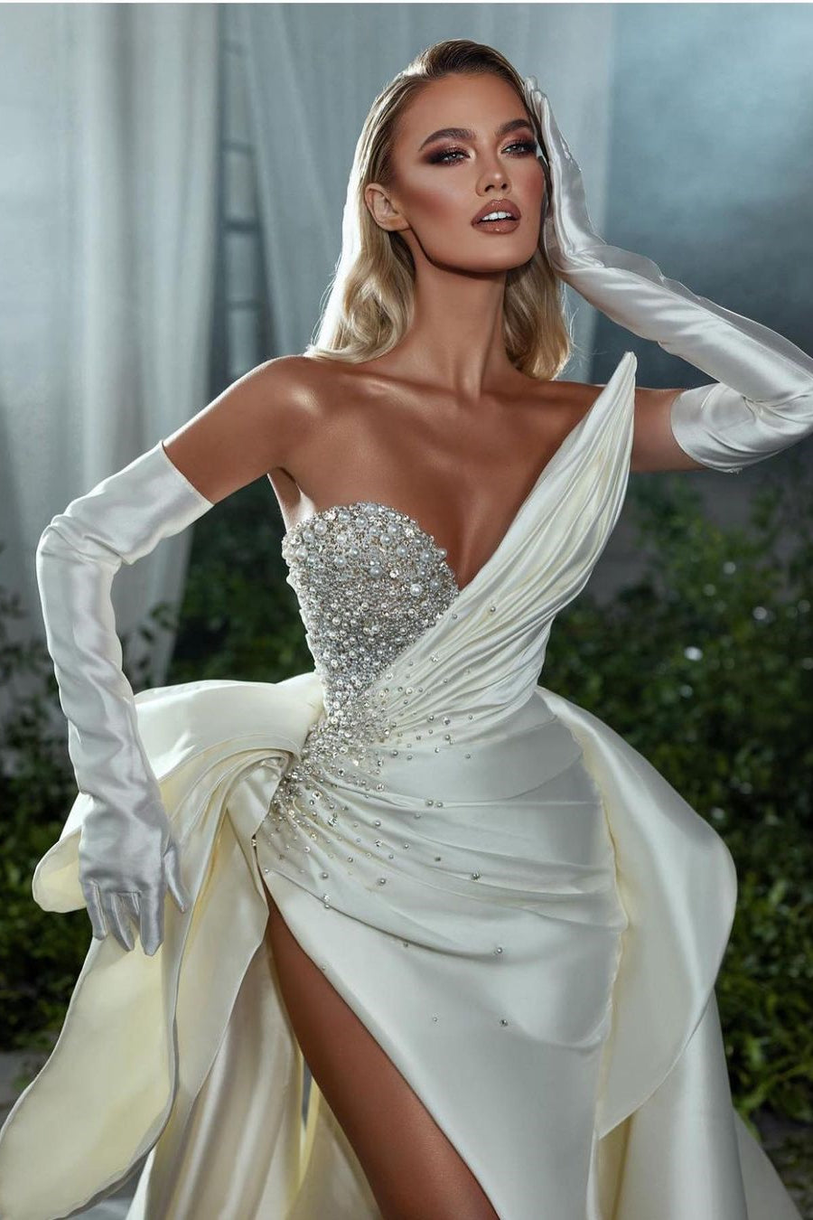 Robe de mariée blanche élégante à col en V, ornée de perles, sans manches, coupe trapèze et fente.