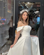 Robe de mariée en satin, coupe trapèze, épaules dénudées, ornée de perles, longueur au sol et perles de rocaille.