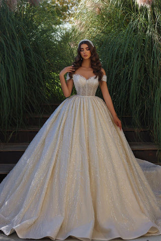 Exquisito vestido de novia largo hasta el suelo, sin mangas, con escote corazón, hombros descubiertos, corte en A, encaje y volantes.