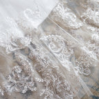 Robe de mariée longue et exquise en tulle et dentelle, coupe trapèze, ornée d'appliqués.