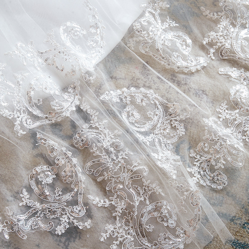 Robe de mariée longue et exquise en tulle et dentelle, coupe trapèze, ornée d'appliqués.