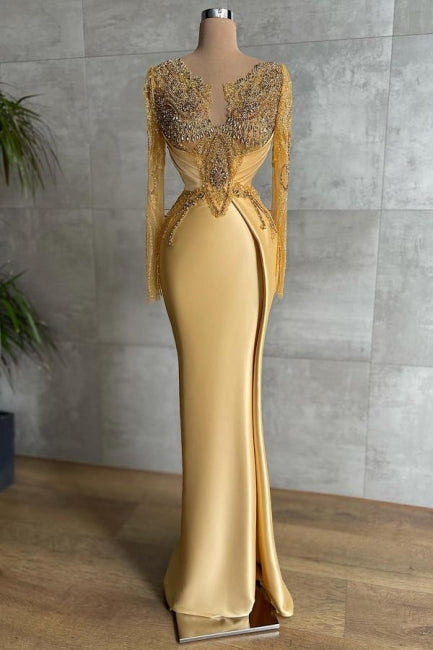 Exquisito vestido de fiesta largo de sirena dorado con encaje y pedrería, de mangas largas.
