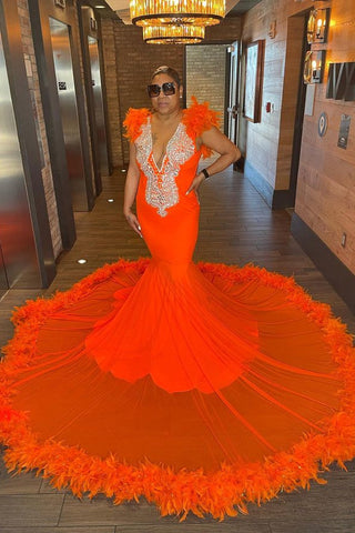 Vestido de fiesta sirena sin mangas con escote en V y plumas, que llama la atención.