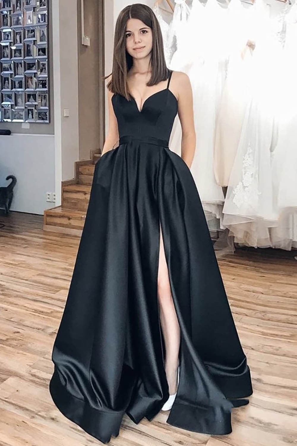 Vestido largo de fiesta negro de corte A con tirantes finos y falda asimétrica.