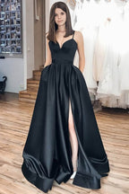 Vestido largo de fiesta negro de corte A con tirantes finos y falda asimétrica.
