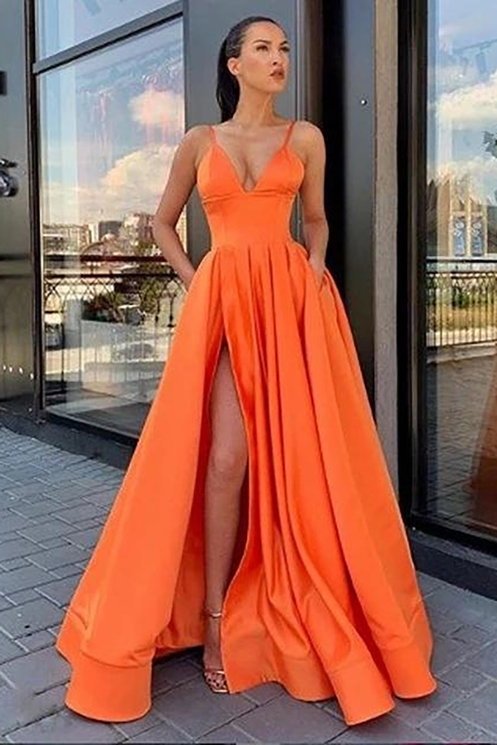 Vestido largo de fiesta negro de corte A con tirantes finos y falda asimétrica.