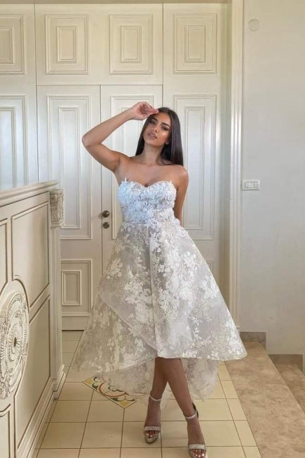 Fabuleuse robe de mariée blanche en dentelle, coupe trapèze, décolleté cœur, sans manches, ornée d'appliques