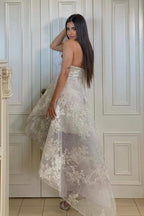 Fabuleuse robe de mariée blanche en dentelle, coupe trapèze, décolleté cœur, sans manches, ornée d'appliques