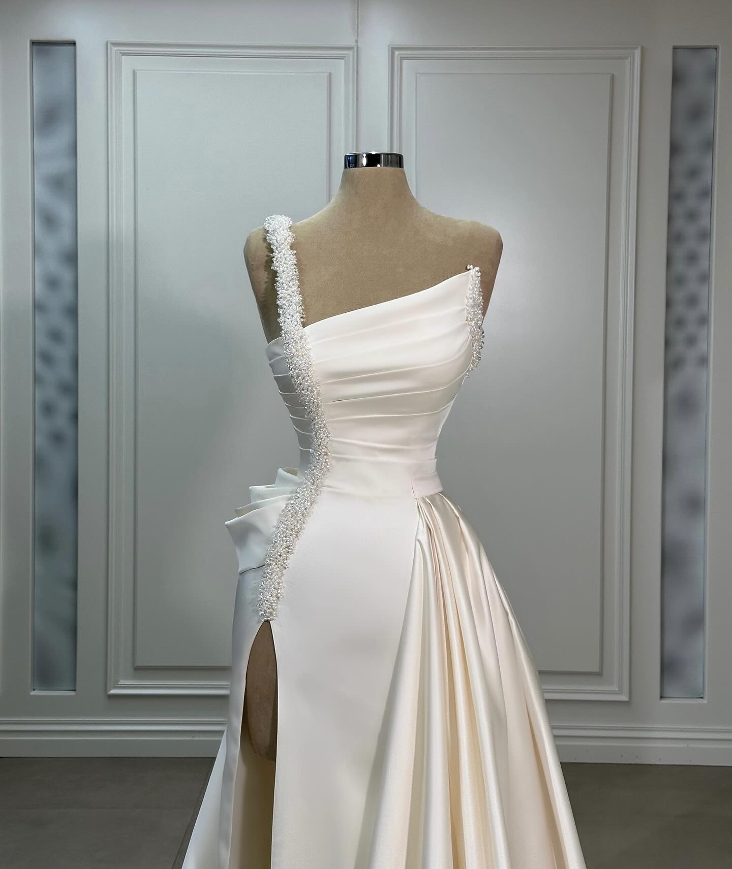 Magnifique robe de mariée trapèze en satin, asymétrique, sans manches, à volants et fendue sur le devant.