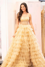 Robe de bal longue princesse en tulle doré, bustier et à volants, fendue.